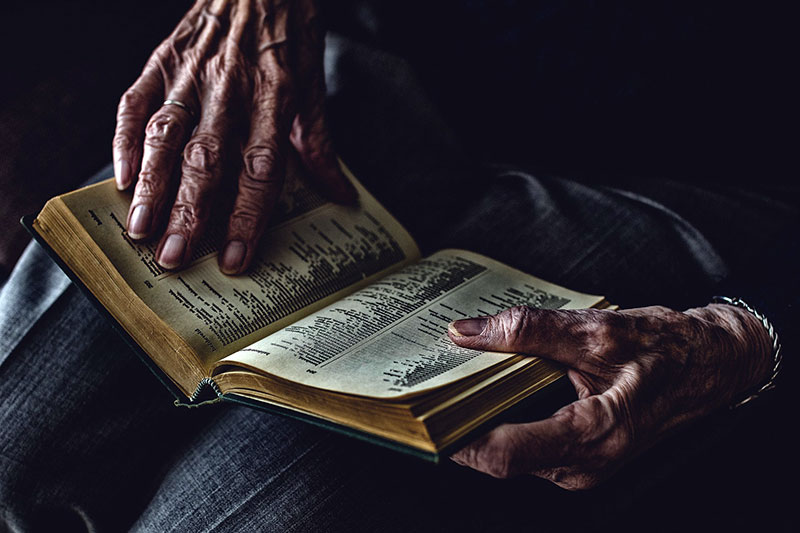 Photo of elderly man reading book
